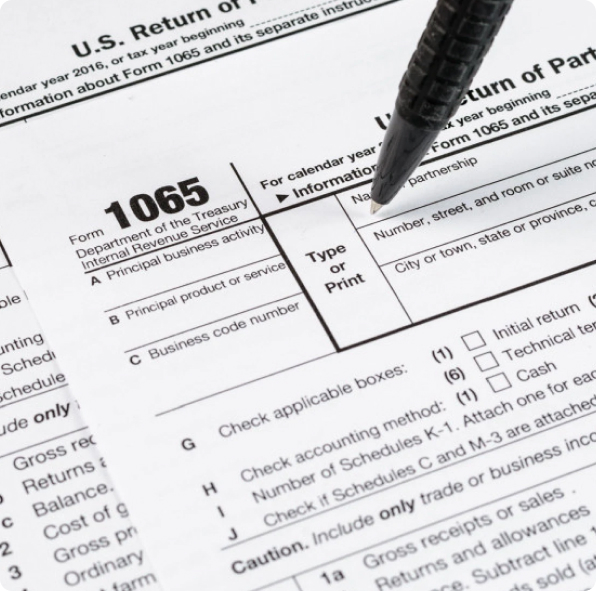 Close-up of IRS Form 1065, the U.S. Return of Partnership Income, with a pen resting on it.